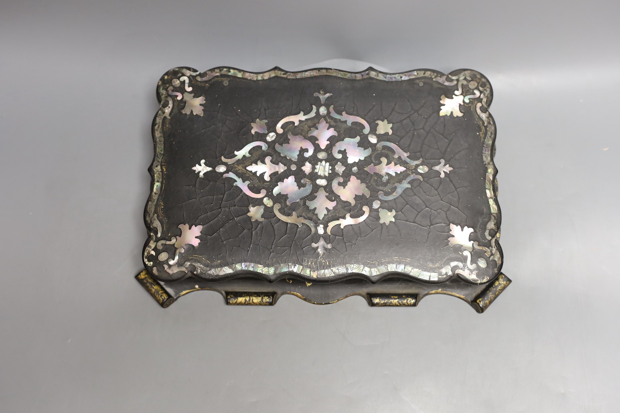 A Victorian papier-mâché games box with mother of pearl inlay and mother-of-pearl counters